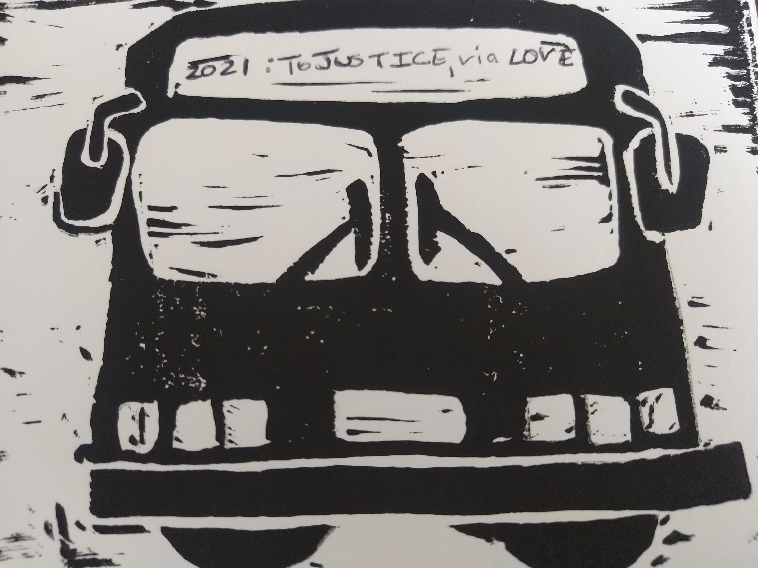 Image description: A black and white block print of a bus. In the area for the route number and destination is the text, "2021: To Justice, via LOVE."